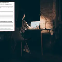 Kobieta wypełnia wniosek o zamrożenie cen prądu przy biurku nocą.